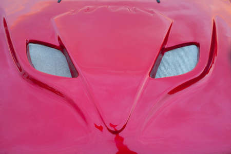 Shiny red car hood with grille shaped as a fox headの写真素材