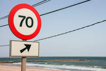 Traffic sign outdoors. Round speed limit road sign on the road beside the seaの写真素材