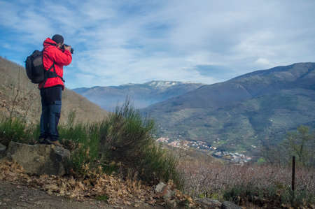 Trekker man taking picture to Jerte Valley on winter. Navaconcejo, Caceres, Extremadura, Spainの写真素材