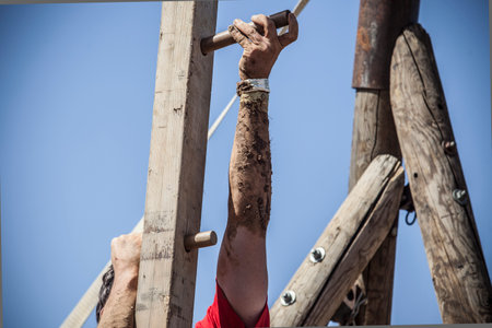 Merida, Spain - Sept 11th, 2022: FarinatoRace Merida 2022. Toughest obstacle course in the world. Climbing up a wooden beam with spikesのeditorial素材
