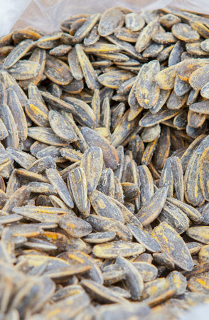 Whole roasted sunflower seeds on rolled up sack. Displayed at street market stallの写真素材
