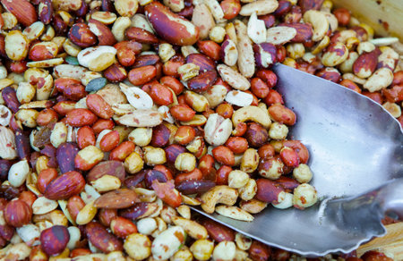 Wooden box with an assortment of fried salty dry fruits. Displayed at street market stall