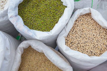 Rolled up sacks full of legumes. Mung beans, lentils and black-eyed peas. Displayed at street market stallの写真素材