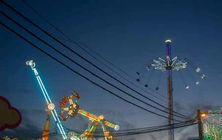 Fairground skyline full of electrical wires and poles. night scene