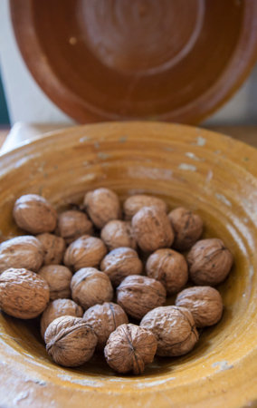 Glazed clay platter full of walnuts. selective focus