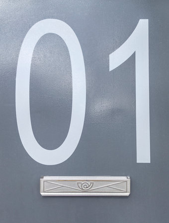 House number 01 on gray metal surface. Houses with personality concept