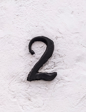 House number 2. Painted iron on whitewashed wall. Houses with personality conceptの写真素材