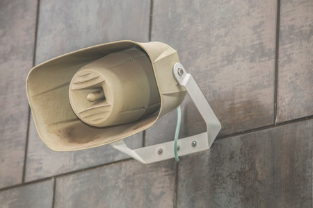 Dusty megaphone attached to modern wall building, Selective focus