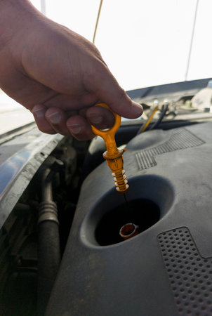 Man checking his oil level from old diesel engine. Petrol station backgroundの写真素材