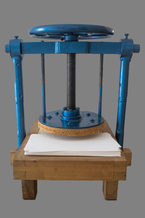 Screw bookbinding press over wooden stand. Isolated over gray backgroundの写真素材