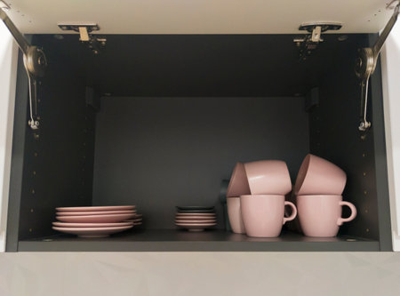 Top kitchen cupboard showing dishware. Handleless cupboards concept