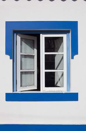 Tiny window painted with vivid colors at Vila Nova de Milfontes house. Little picturesque town on the Alentejo coast, Portugalの写真素材
