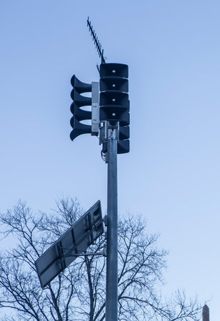 Solar-powered horn loudspeakers pole. Dawn blue light background