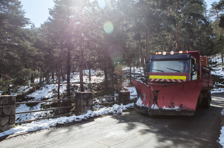 Snowplow truck crossing a bridge. Visible sun flares