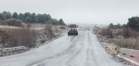 Snow plow patrolling the road in a sleet. North Spain roadのeditorial素材