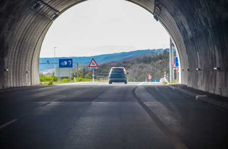 Vehicle coming out of a tunnel on a highway. View from inside