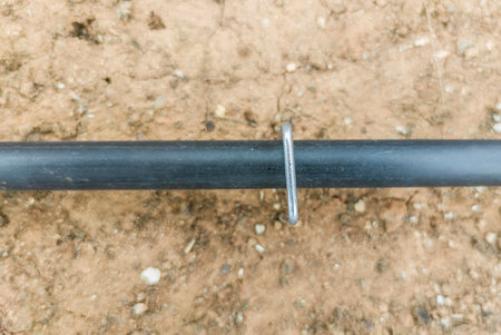 U pins or hold down pegs installed over pipe. Gardening equipment for drip irrigationの写真素材