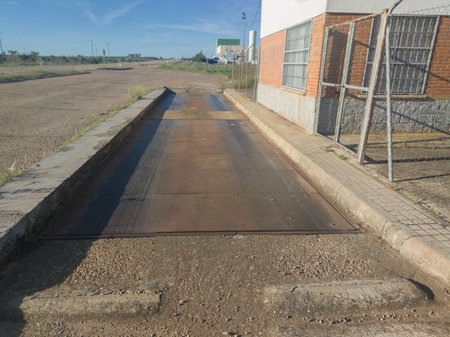 Truck scale installed on the right side of a local road. Facility used to weigh entire vehicles and...