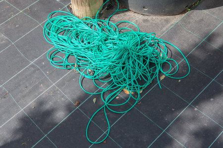 Flexible garden tying tube displayed over weed membrane. Gardening supply concept