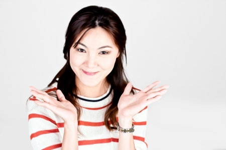 Smiley Asian woman in red t-shirt with empty copyspace on open hanの写真素材