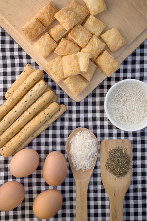 Fresh baked homemade grissini bread sticks and  crispy pie with egg and wood spoon on vintage fabric backgroundの写真素材