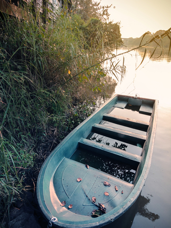 green painted rusty  rowing boat with a  seat plate which abandon at the river in vintage moodの写真素材