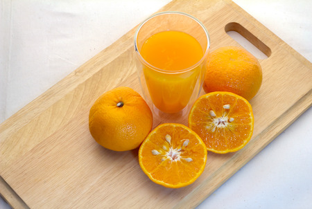 Oranges cut set  and glass of orange juice on wooden baseの写真素材