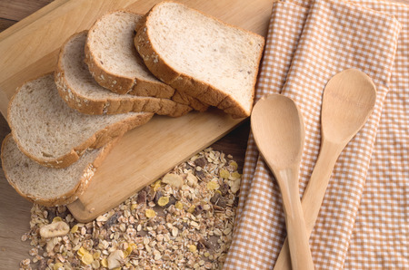 slice bread and wheat grain on cutting board and wood spoon.jpg
