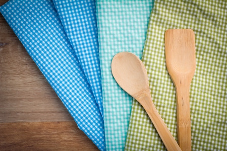 colorful checkered tablecloth with wooden spoons on dark wooden table.jpgの写真素材