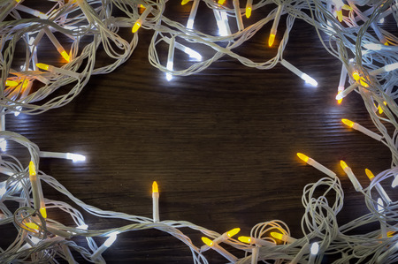 Christmas lights glowing on wooden backgroundの写真素材