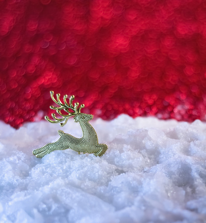 Christmas decoration deer covered with snow and red backgroundの写真素材