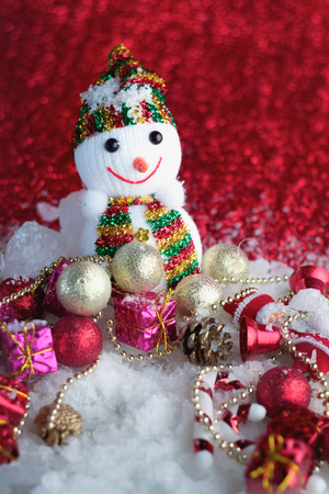 Snowman on a red fabric background and snow with shiny balls.jpgの写真素材