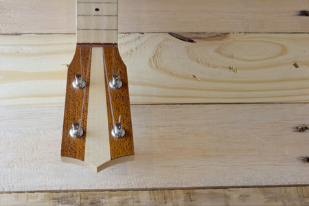 close up ukulele on wooden background with copy sapce on the right