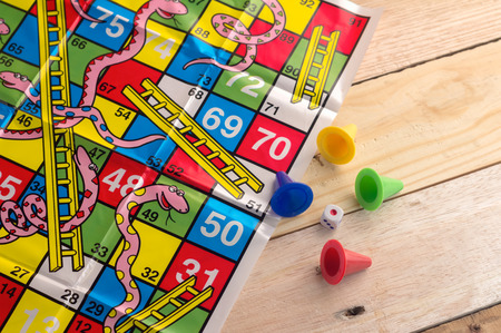 colorful play figures with dice on board and wooden table