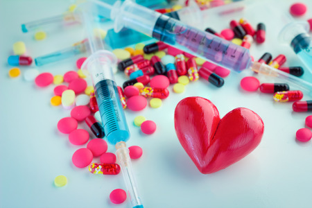 Medical concept : One red heart on Colorful Pills and injection With white backgroundの写真素材