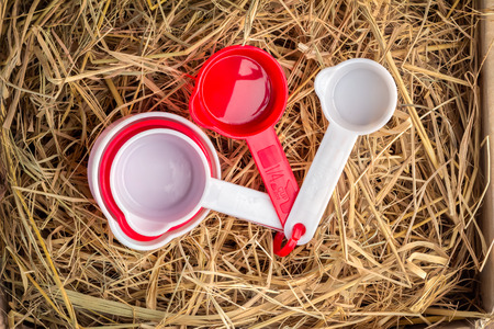 Red measurement spoons on  hay texture background