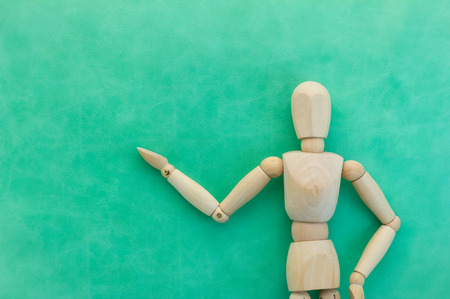 wood man figure presenting and showing something on color backgroundの写真素材