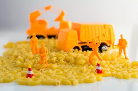 uncooked pasta and set of workmen on a white background food industry conceptの写真素材