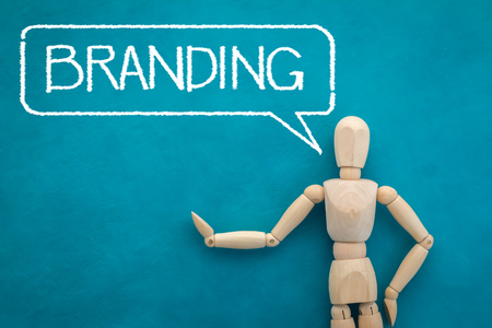 wood man figure presenting branding word on color backgroundの写真素材