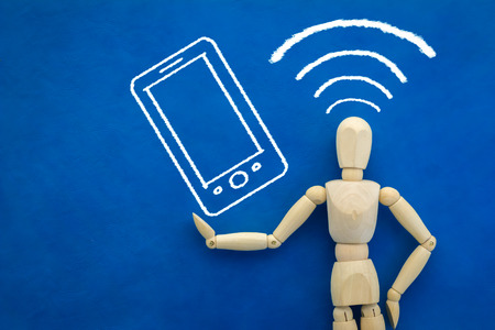wood man figure with drawing of smartphone on color backgroundの写真素材