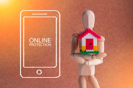 wooden man holding home model. home security concept conceptの写真素材
