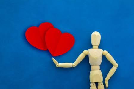 wood man figure with red paper heart shape on color backgroundの写真素材