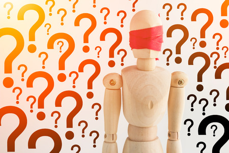 wood man figure blind with red ribbon with question mark background decision conceptの写真素材
