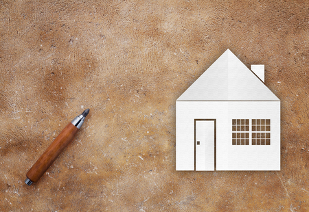 house paper cut with pencil on brown texture background house conceptの写真素材
