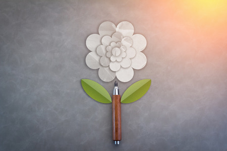 Cutout white paper flowers with wooden pencil on grey backgroundの写真素材