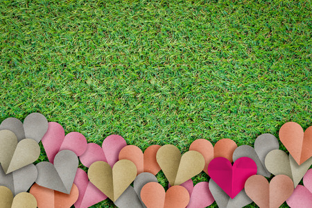 heart shape paper cut with pastel color on green grass texture background and copy space for your textの写真素材