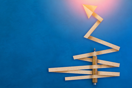 paper cut arrow direction with wooden pencil on blue leather backgroundの写真素材