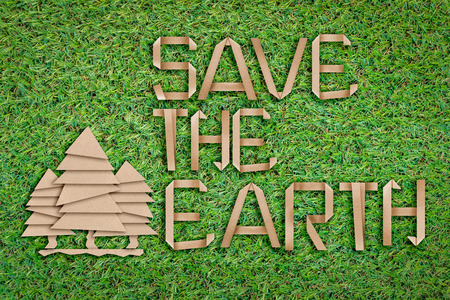 save the earth concept with text and tree shape paper cut flat style on green grass field backgroundの写真素材