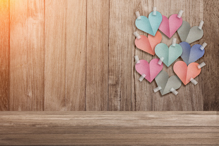 colorful heart shape paper cut stick on old wooden background with copy space and light flare effectの写真素材
