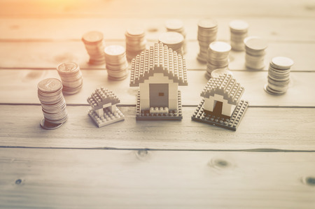 House models with stacked coins at wooden table business  asset conceptの写真素材